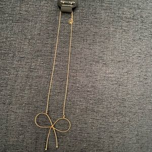 Gold bow necklace with gold ball earrings.